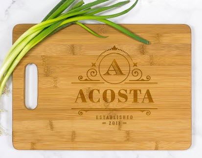Personalized-Bamboo-Cutting-Board-With-Handle1 | Food For Net Light-colored cutting board with Acosta engraved on it.