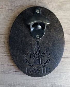 A wall-mounted beer bottle holder with engraving.