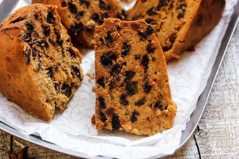 A tray with a piece of paper and pieces of rum and raisin cake