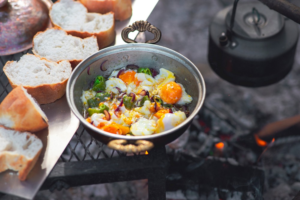 A frypan with cooked vegetables and rice, next to slices of bread