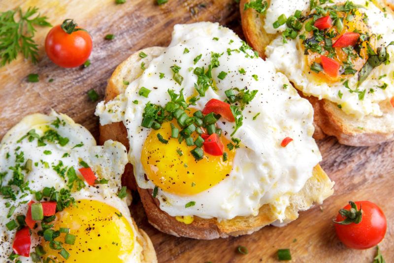 Three pieces of toast with eggs and herbs