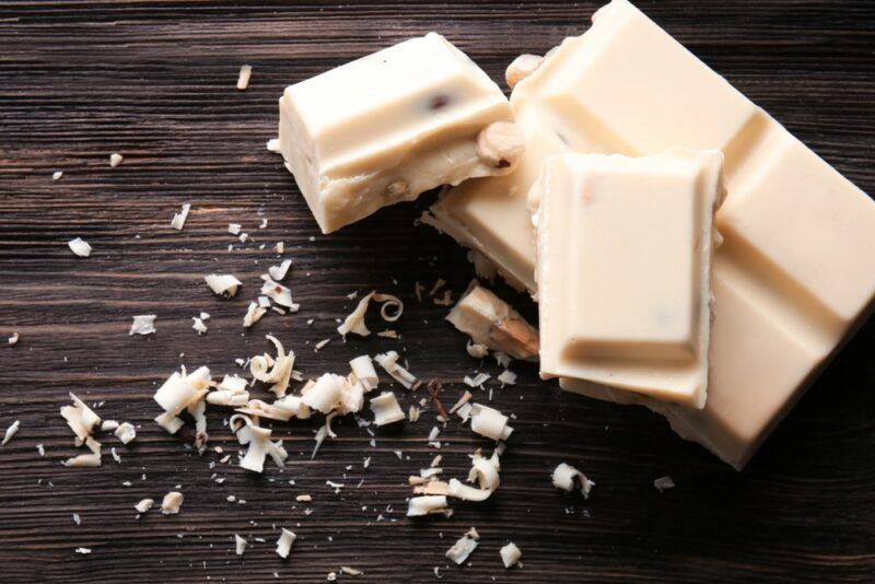 A wooden table with squares of white chocolate