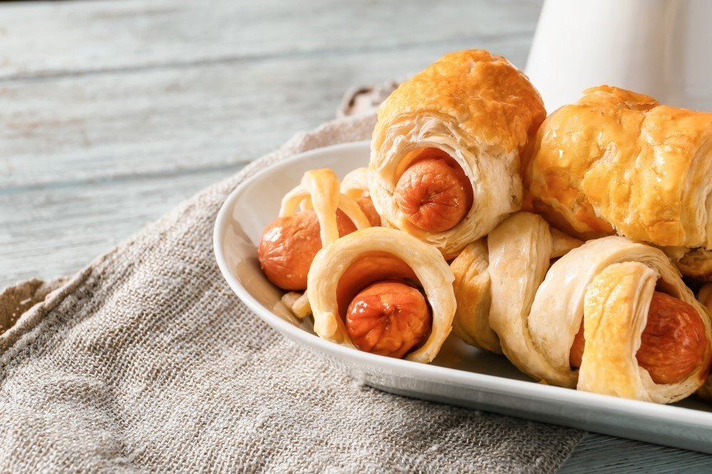 A white plate with pigs in blankets