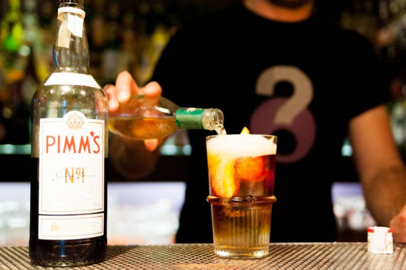 A bottle of Pimms with a cocktail