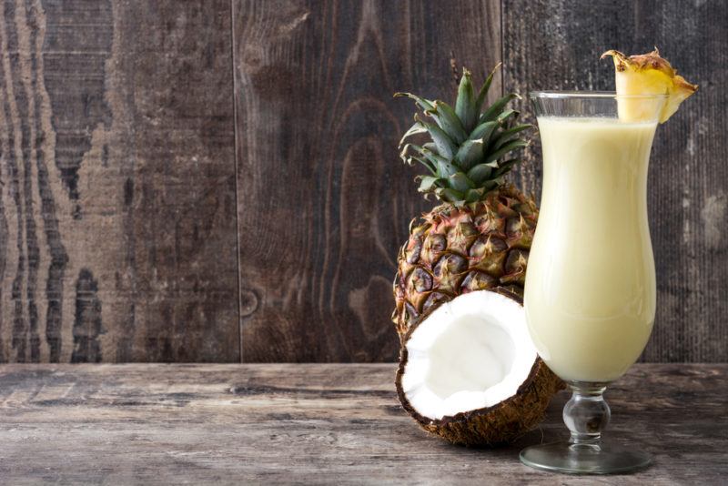 A pina colada, coconut and pineapple on a wooden table