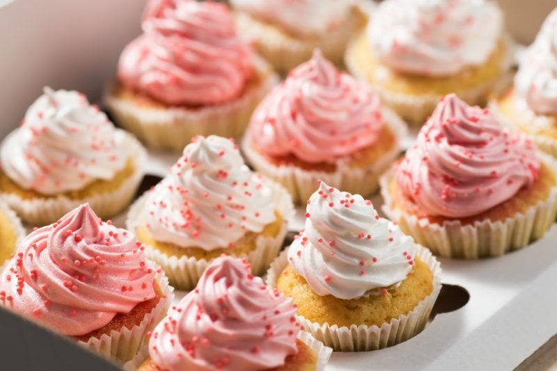 A selection of cupcakes with pink and white icing