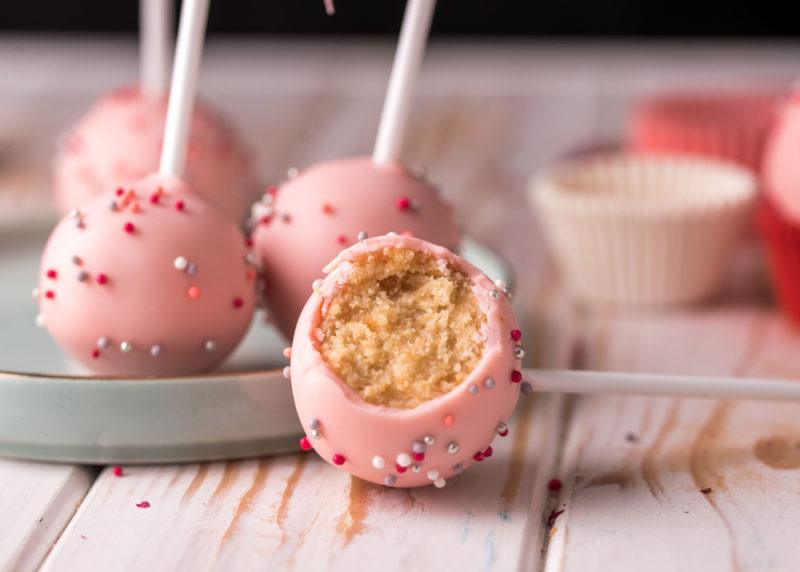 Pink cake pops on sticks with sprinkles