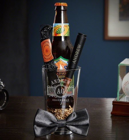 Pint glass with a bow tie, beer, knife and bullet bottle opener