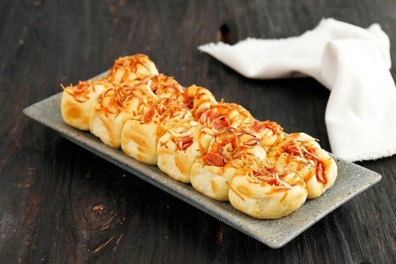 A light gray plate with homemade pizza pull apart bread