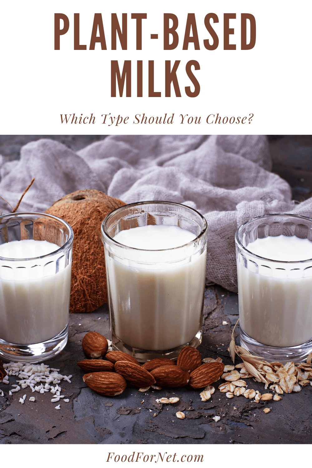 Three glasses of plant-based milks, with oats, coconuts, almonds and rice scattered around