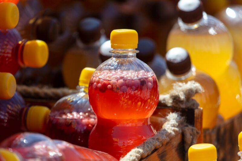 A variety of plastic bottles with mead of different colors, plus some type of bubble