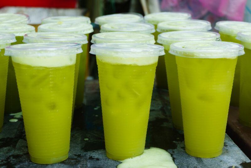 Plastic cups with lids containing sugarcane juice and ice