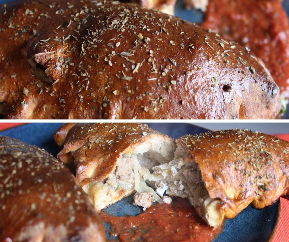 baked whole wheat calzone split open to reveal meat and veggies inside