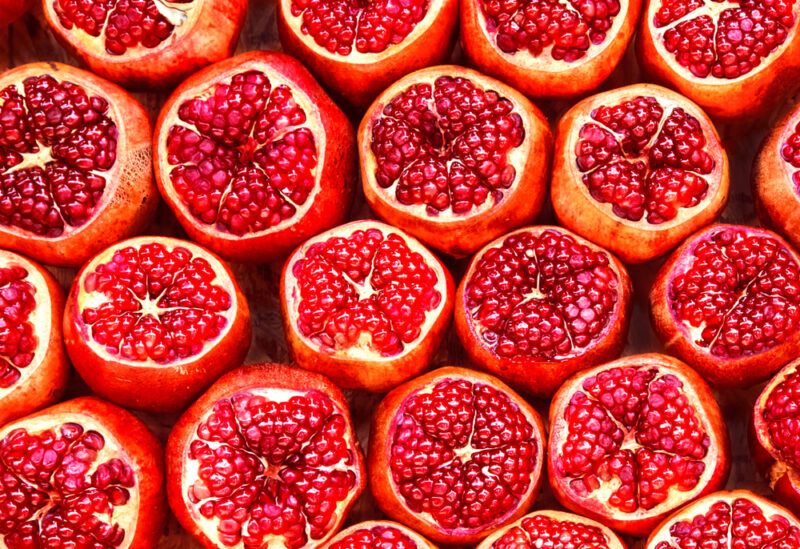 This photo shows an overhead view of several opened pomegranate fruits.