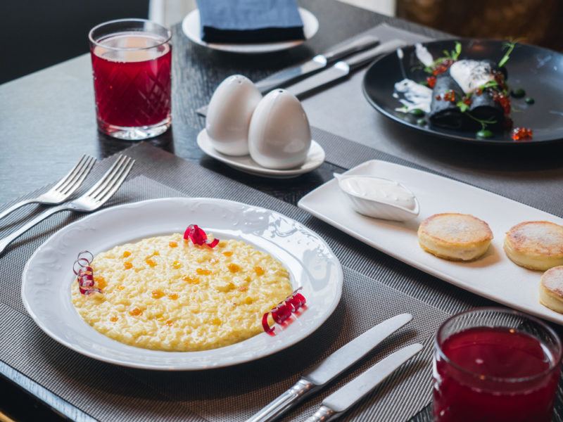 A white plate of porridge being served at a restaurant