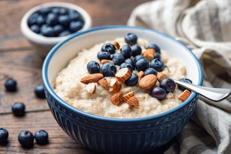 A blue bowl of porridge with blueberries and almonds