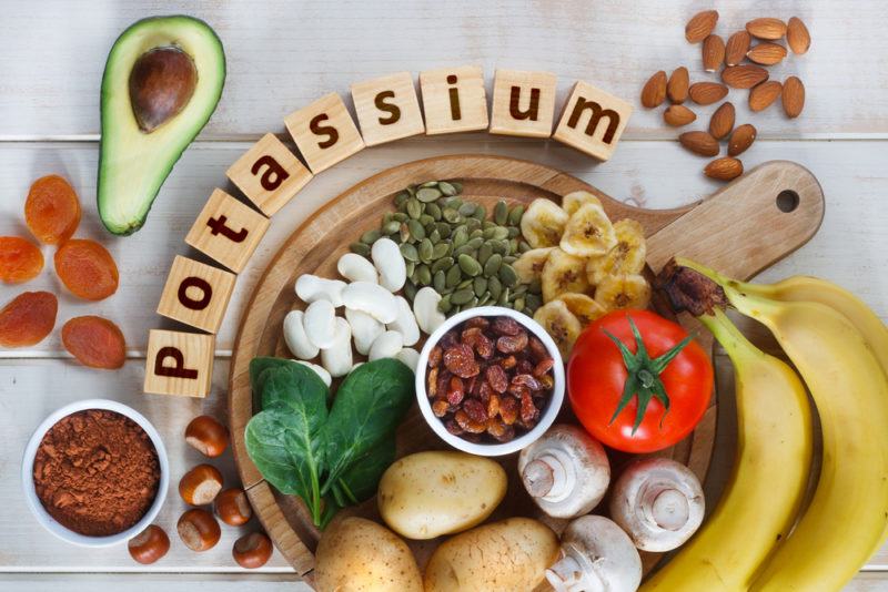 Potassium rich foods on a wooden table, including bananas