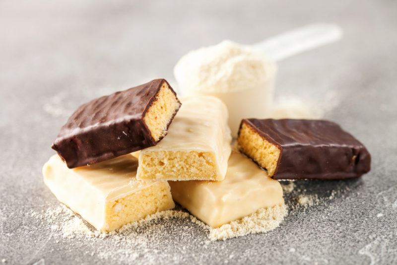 Chocolate and vanilla protein bars, with a pscoop of protein powder