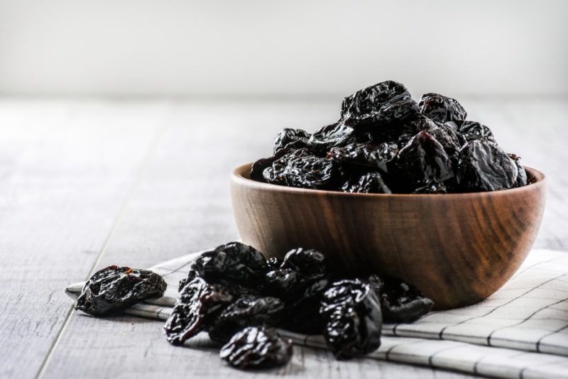 A wooden bowl with prunes