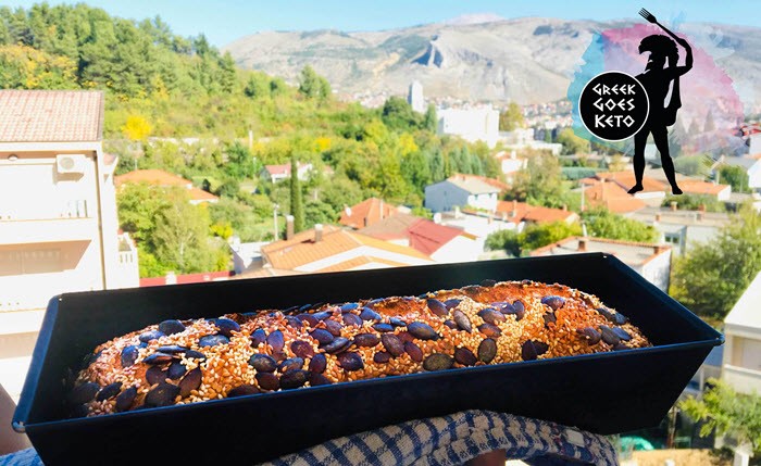 Pumpkin seed bread in a black pan in front of a beautiful view