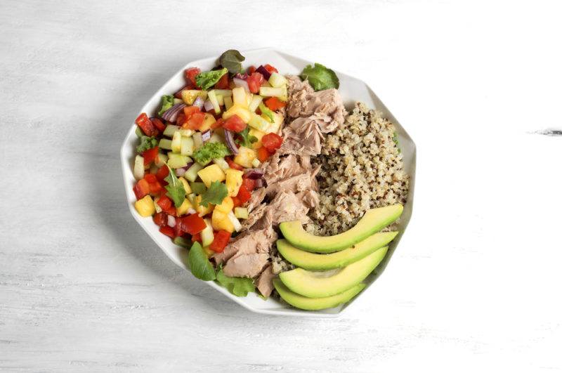 A white bowl that includes avocado, quinoa and tuna