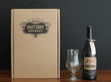 A large bottle of beer, glass and box on a wooden table. 