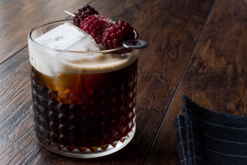 A glass of coffee cocktail with raspberries