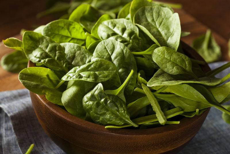 A bowl of raw spinach ready for cooking