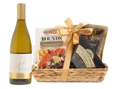 Raymond R Chardonnay & Cheese Gift Basket | Food For Net A small basket with cheese and snacks, next to some wine.