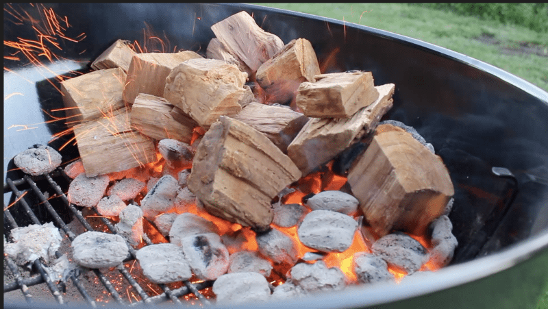 wood burning on charcoal in a weber grill