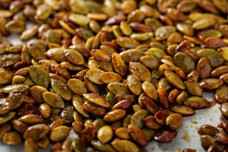 Roasted and seasoned pumpkin seeds on baking paper