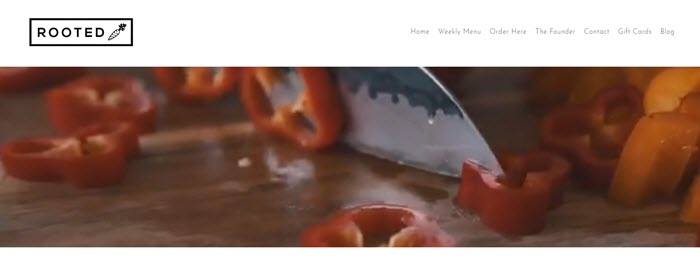 A video still of a knife cutting red peppers. 