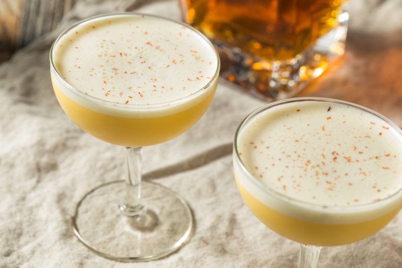 Two glasses of a rum flip cocktail on a white table