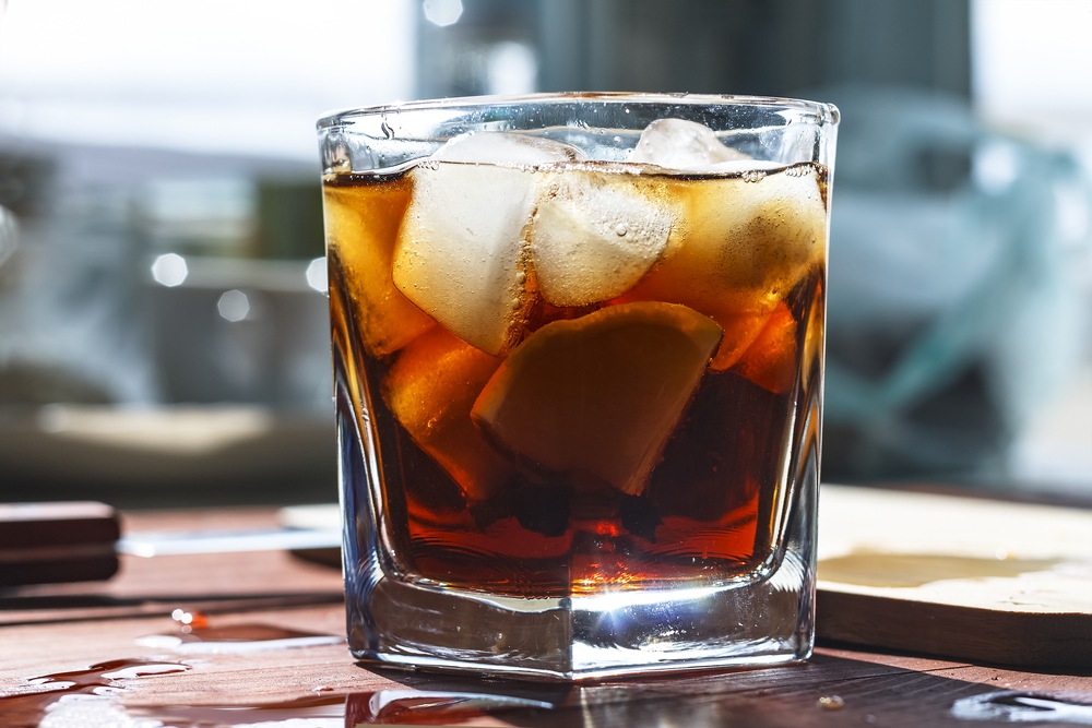 A glass with rum, coke and plenty of ice