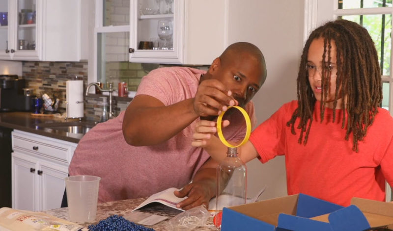 A father and daughter in the kitchen working on a STEM Deluxe science kit