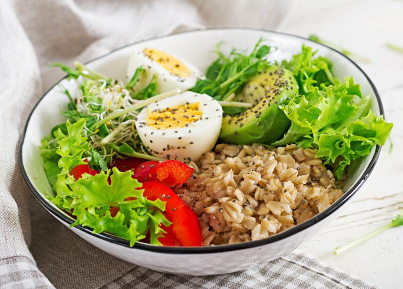 A savory oatmeal bowl with eggs and lettuce as toppings