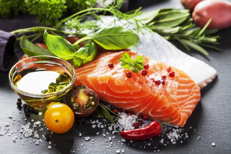 Fresh salmon on a table with herbs and other fresh ingredients