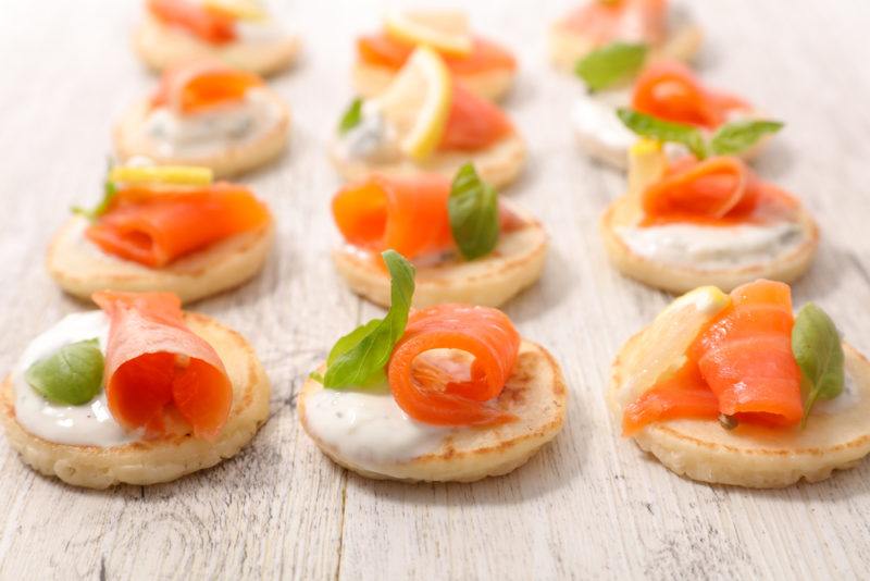 A table of some type that contains salmon and cream cheese canapes