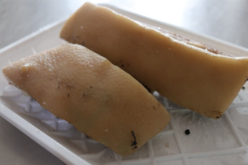 Two pieces of pork belly on a tray