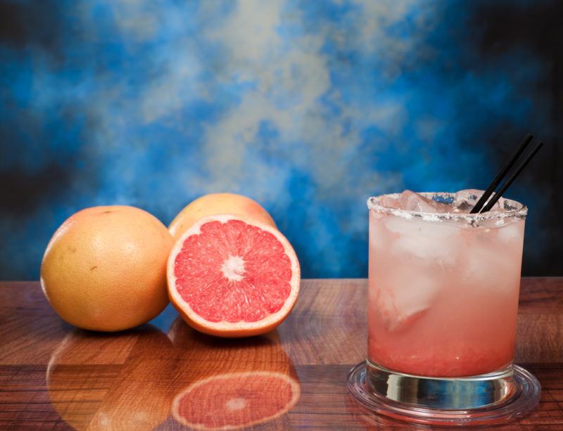 A grapefruit cocktail with grapefruit on a table