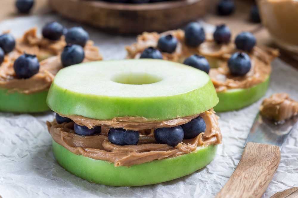 Two open-faced sandwiches using peanut butter and blueberries, along with one regular sandwich