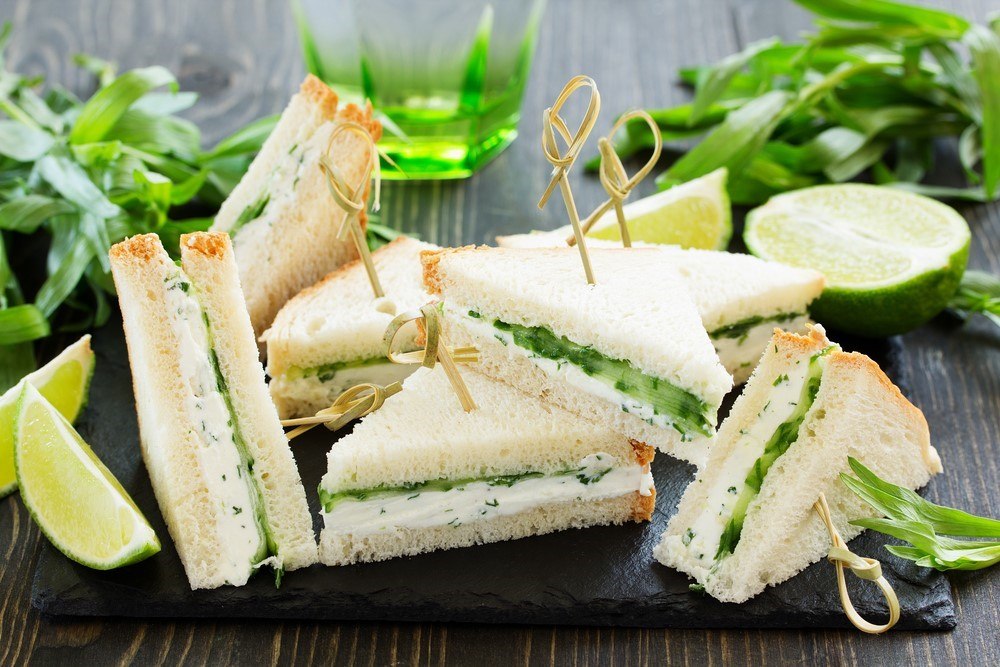 Small triangular sandwiches made using cucumber and cream cheese