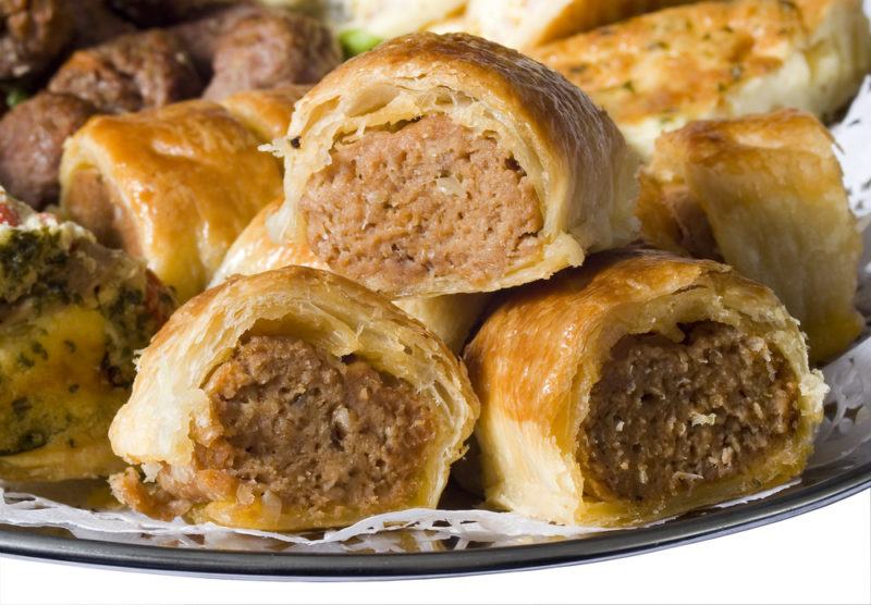 A pile of small sausage rolls on a plate