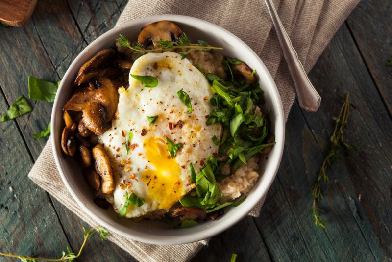 A savory oatmeal bowl that includes an egg and greens