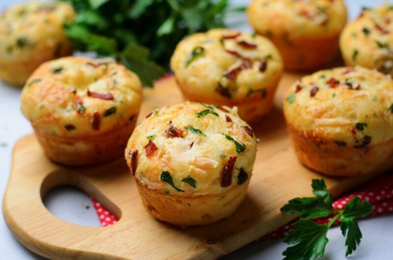 A wooden board that contains a variety of savory muffins