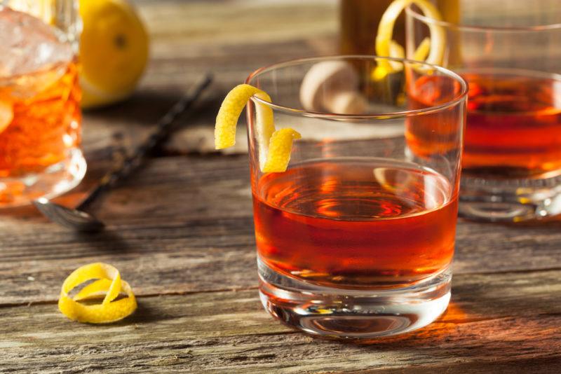 Three sazerac cocktails in glasses on a wooden table