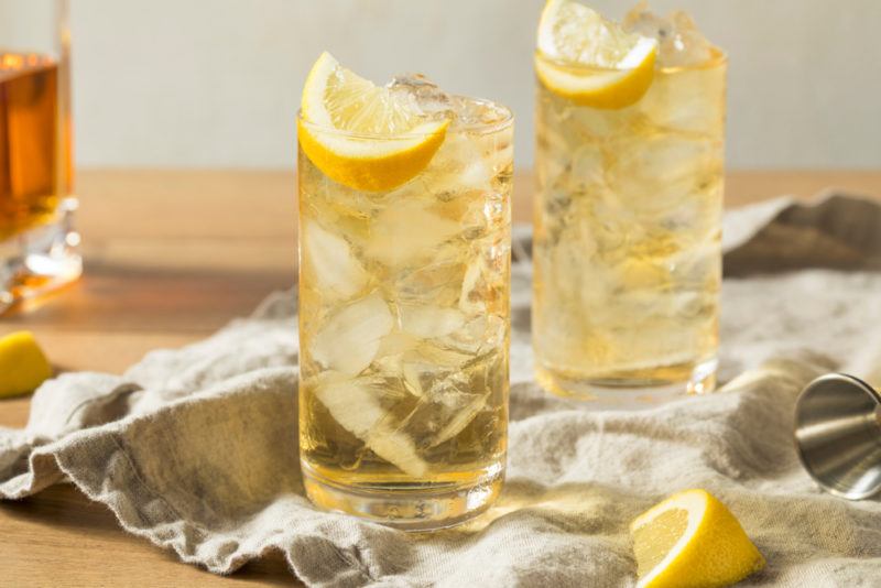 Two glasses of seven and seven cocktail with ice and lemons