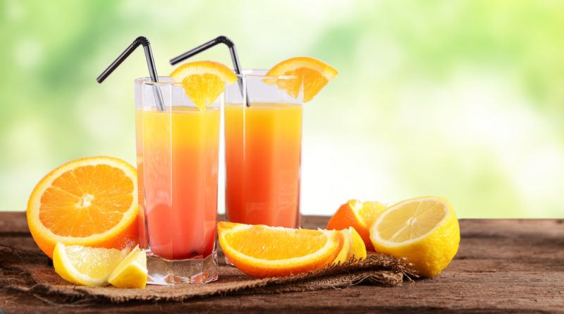 Two glasses of sex on the beach with sliced oranges and straws