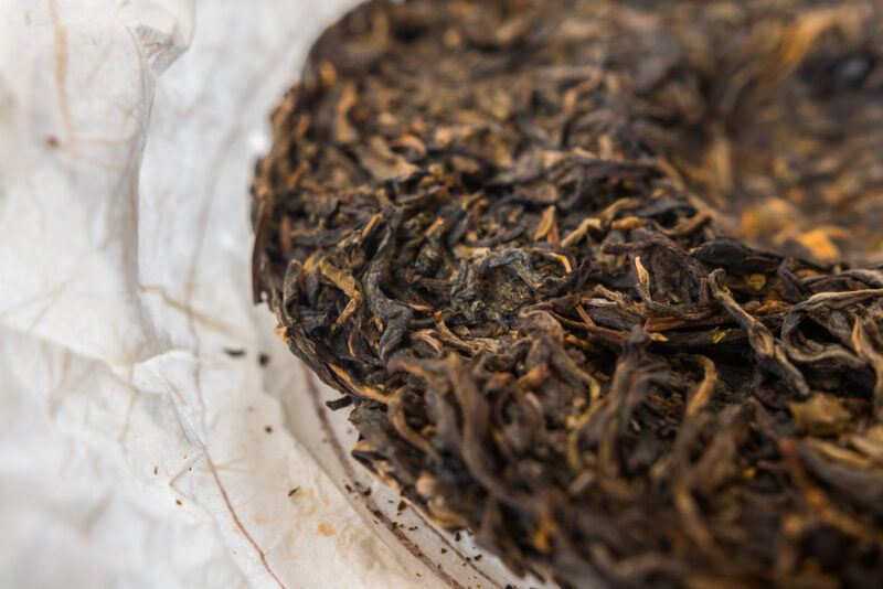 a closeup image of white paper with a dense pile of Sheng Pu-Erh tea