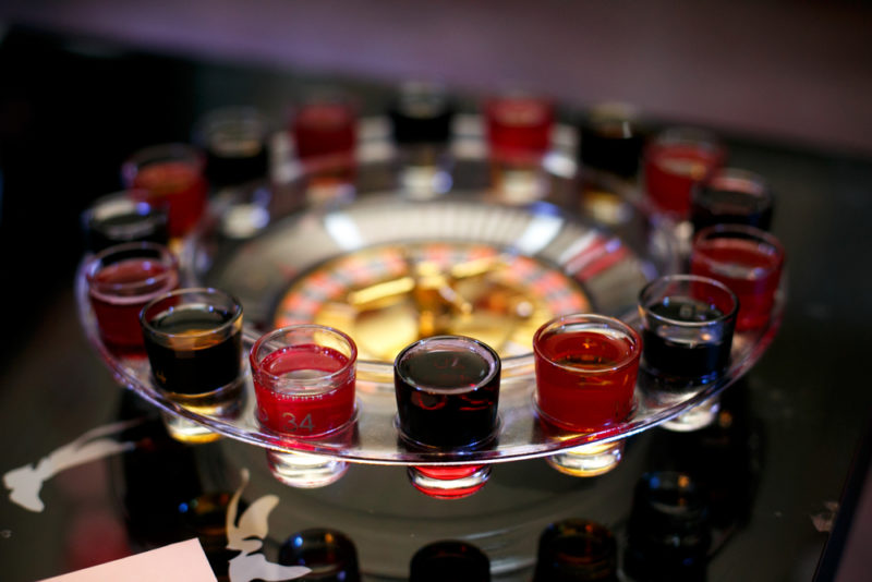 A roulette wheel with different shot glasses